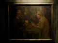 Obraz: dwaj mężczyźni w kapeluszach grają w karty przy stole. Jeden z nich pali fajkę.