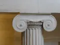 Kamienna kolumna w stylu jońskim z charakterystycznymi wolutami.