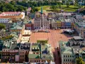 Zamość miasto idealne: renesansowy rynek z kolorowymi kamienicami i ratuszem, otoczony zielenią.