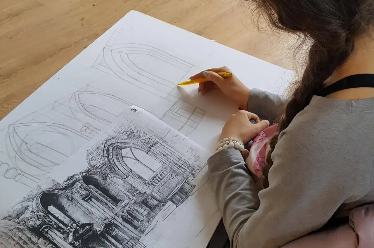 Młoda artystka szkicuje detale architektoniczne, przygotowując się do matury z architektury wnętrz.