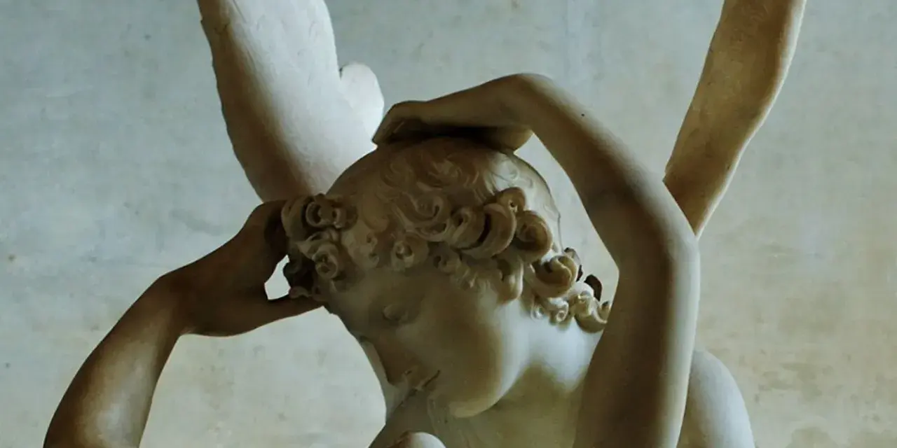 Rzeźba Amor i Psyche. Skrzydlaty Amor budzi pocałunkiem śpiącą Psyche, ich ciała splatają się w czułym uścisku.