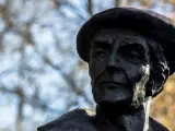 Portret rzeźbiarski w ciemnym brązie, ukazujący twarz mężczyzny w beretce. Widać głębokie zmarszczki i wyraziste rysy, oddające estetykę dzieł Kenara.
