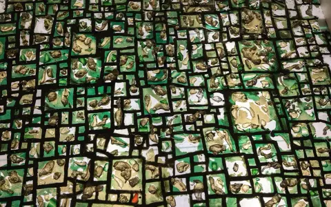 Abstrakcyjna mozaika z zielonych i beżowych fragmentów, przypominająca mapę myśli lub wizualizację filozofii.