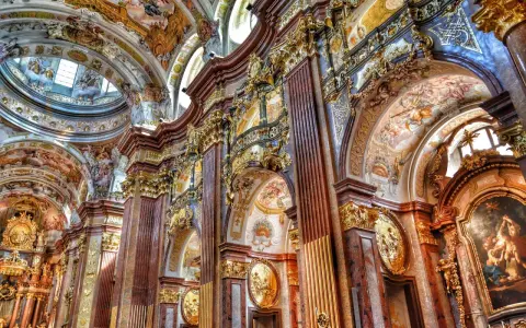 Bogata architektura baroku zachwyca złotymi zdobieniami, marmurowymi kolumnami i freskami na sklepieniach.