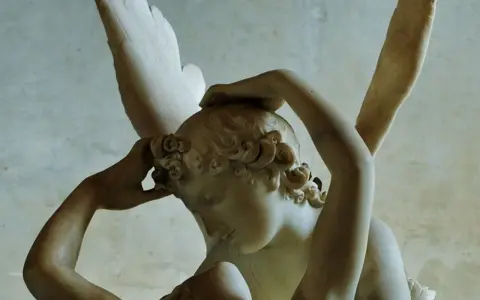 Rzeźba Amor i Psyche. Skrzydlaty Amor budzi pocałunkiem śpiącą Psyche, ich ciała splatają się w czułym uścisku.