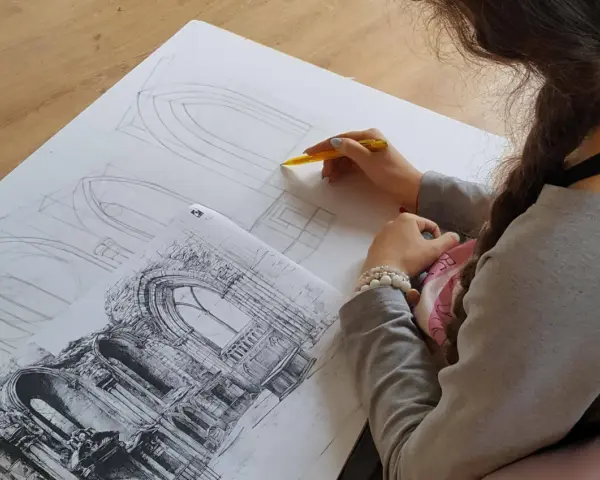 Młoda artystka szkicuje detale architektoniczne, przygotowując się do matury z architektury wnętrz.