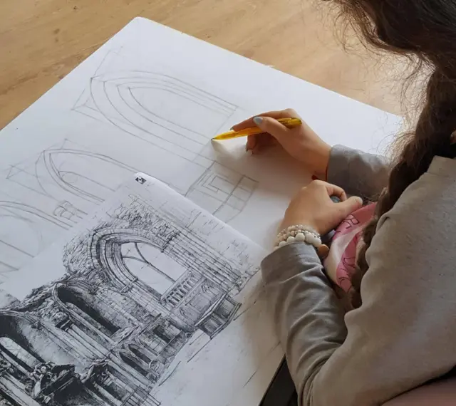 Młoda artystka szkicuje detale architektoniczne, przygotowując się do matury z architektury wnętrz.