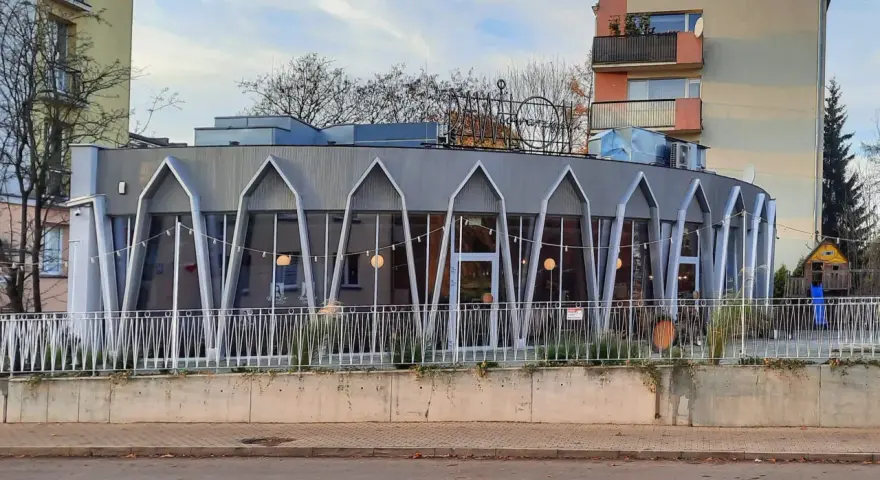 Charakterystyczna modernistyczna architektura budynku z przeszkloną fasadą i geometrycznymi elementami.