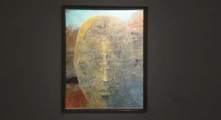 Jedna z najsłynniejszych obrazów Beksińskiego: surrealistyczna, złocista twarz wyłaniająca się z mroku, pełna tajemniczych detali.
