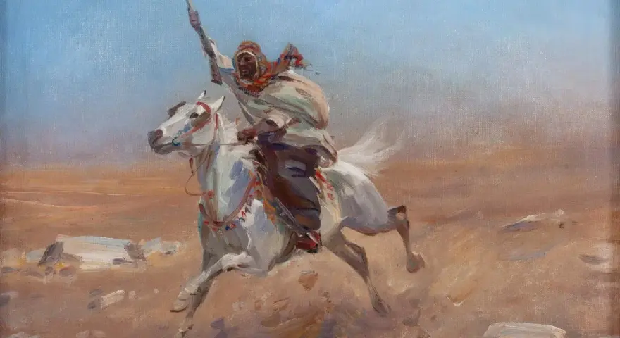 Biały koń galopuje przez pustynię, dosiada go wojownik w tradycyjnym stroju, z uniesioną włócznią. Obraz w stylu orientalizm.