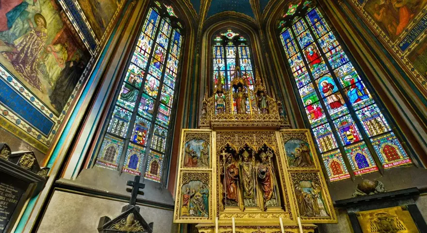 Wnętrze kościoła z witrażami i ołtarzem, przykład akademizmu.