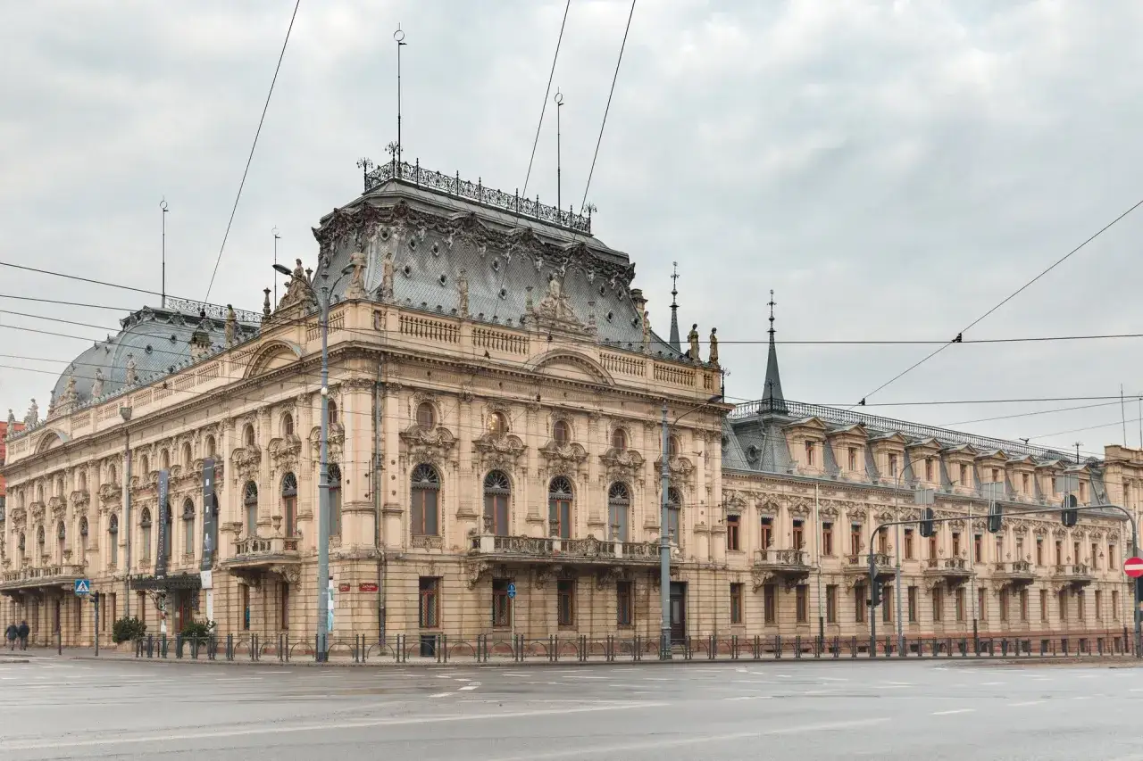 Imponująca, zabytkowa kamienica w stylu polskiej architektury, z bogatymi zdobieniami i mansardowym dachem.