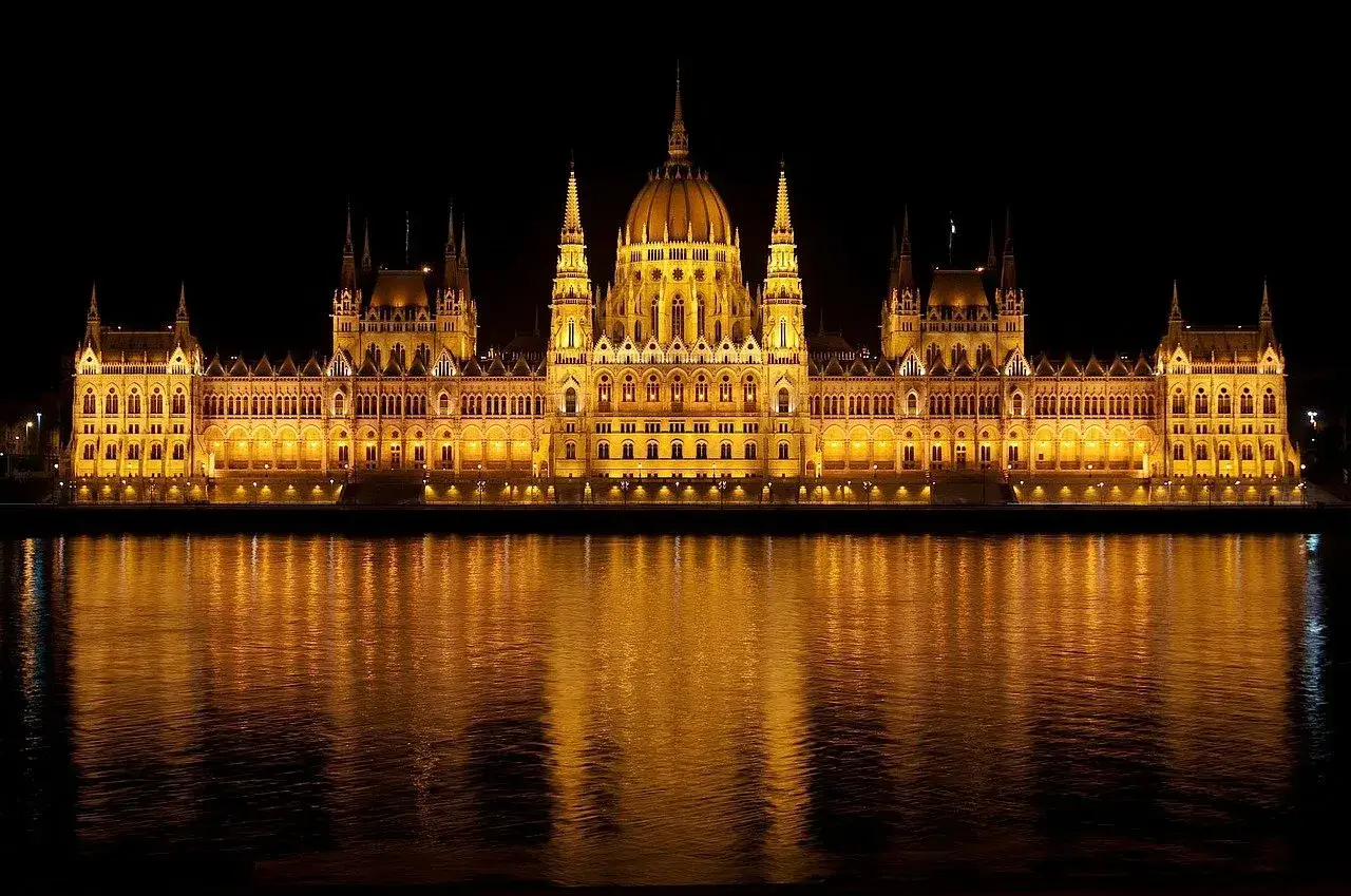 Wspaniała budowla w stylu romantyzm architektura, nocą, z odbiciem w wodzie.