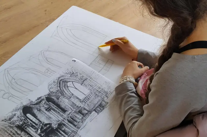 Młoda artystka szkicuje detale architektoniczne, przygotowując się do matury z architektury wnętrz.